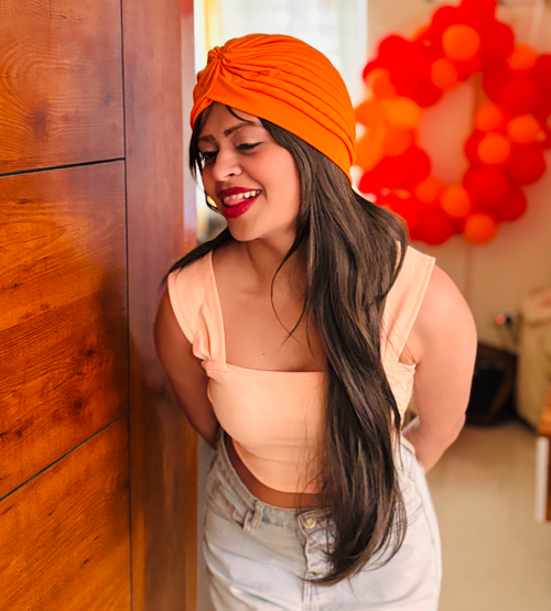 Sunday Wig on model – Brown Wavy Synthetic Hair

FLAWNT-IT Wig with Orange Turban – Styled Shot

Long synthetic wig for women – Indian skin tone